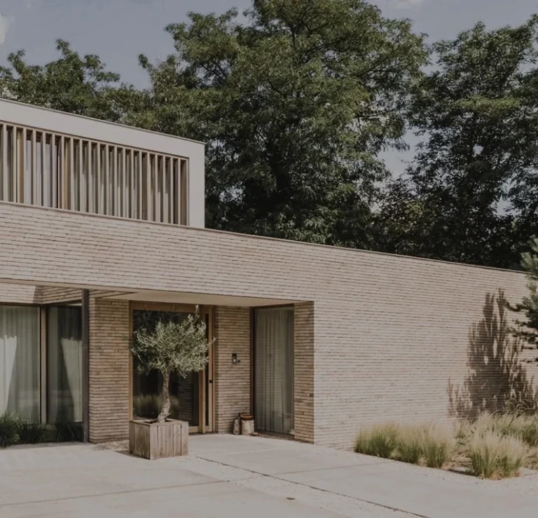 Modernt hus med naturmaterial och stora fönster, omgiven av grönska, av arkitekt mabeldesignstudio